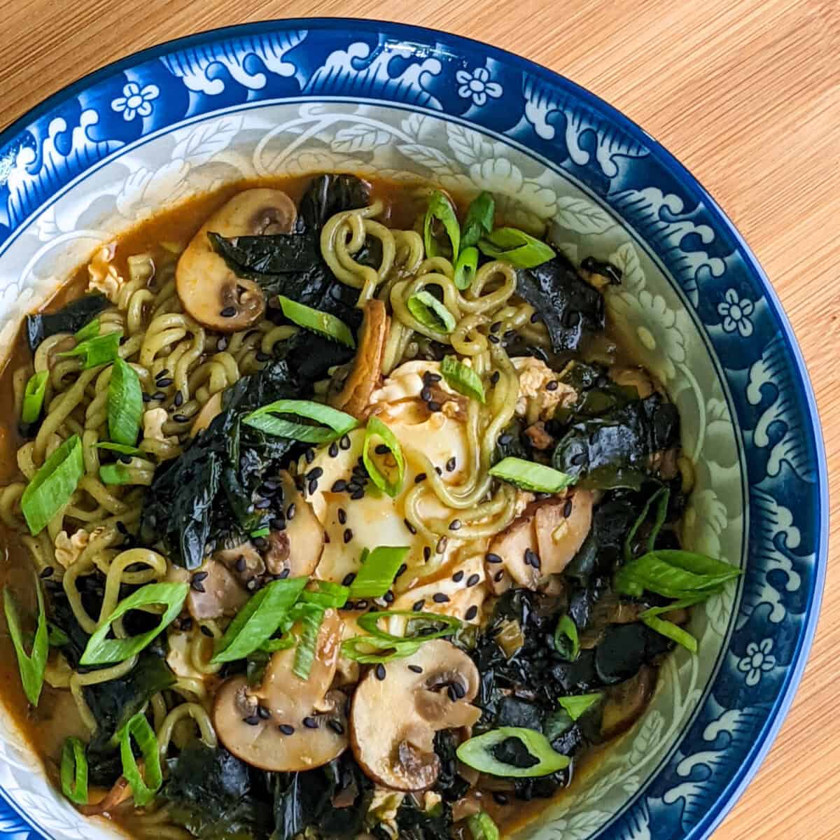 Hearty beef and seaweed ramyun topped with greens, served in a decorative bowl.